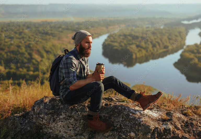 man on mountain with coffee success