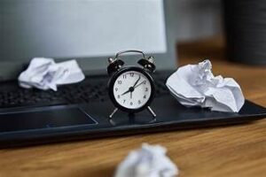 Clock surrounded by crumpled paper symbolizing wasted time